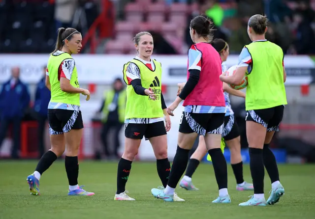 Kim Little of Arsenal interacts with teammate Lotte Wubben-Moy as they warm up prior to the Barclays Women's Super League match between Brighton & Hove Albion FC and Arsenal FC at Broadfield Stadium on May 05, 2025 in Crawley, England.