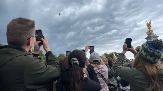 Crowds filming plane flying by