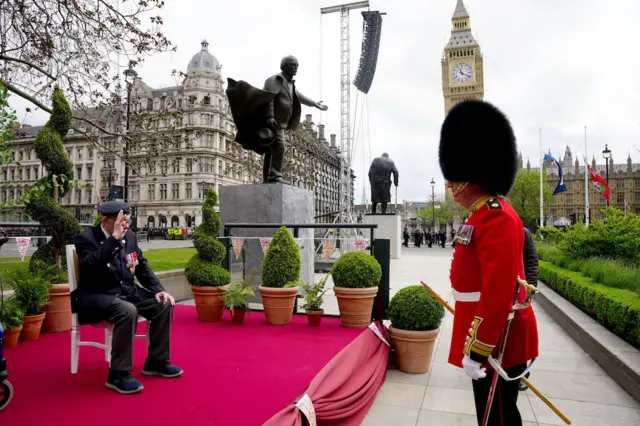 Second World War veteran Alan Kennett speaks with a member of the Band of the Irish Guards, near Parliament Square