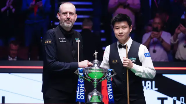 Mark Williams and Zhao Xintong with the World Championship trophy