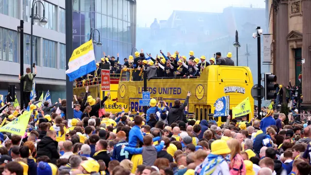 Thousands of fans cheer as the team bus makes its way through town.