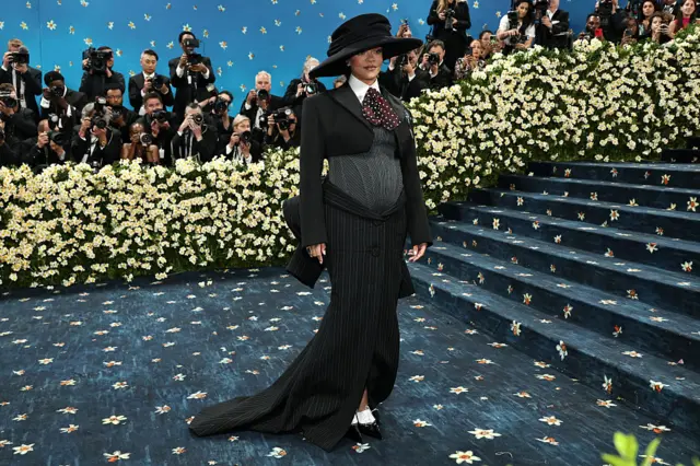 Rihanna wearing all-black dress and a big round black hat