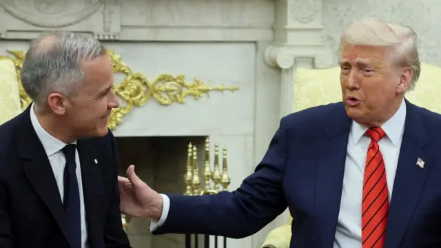 Trump pats Carney on the should as the two speak, both still seated