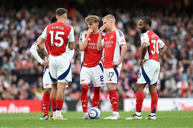 Martin Odegaard of Arsenal speaks with teammates Oleksandr Zinchenko, Jakub Kiwior, Raheem Sterling as they prepare for a free kick