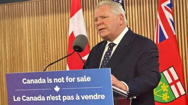 Doug Ford speaks behind a podium with the words: Canada is not for sale.