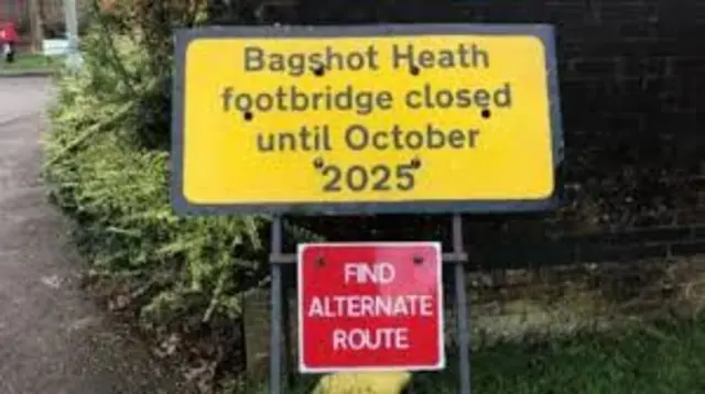 Roadworks signs in yellow and red at a junction in Surrey
