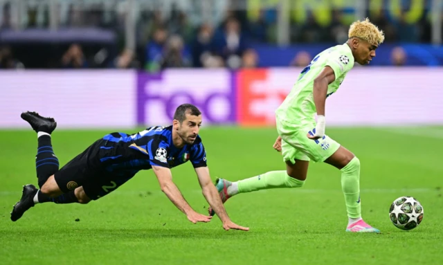 Inter Milan's Henrikh Mkhitaryan in action with FC Barcelona's Lamine Yamal