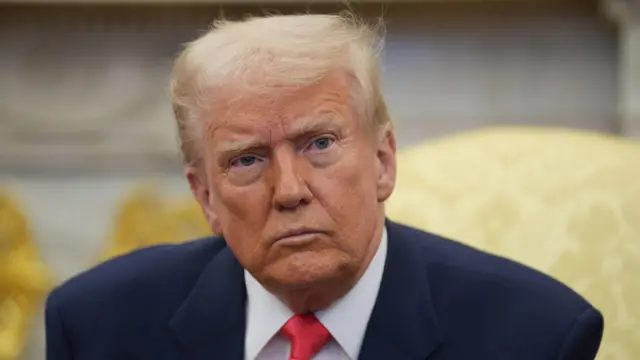 Donald Trump wearing a navy suit and red tie