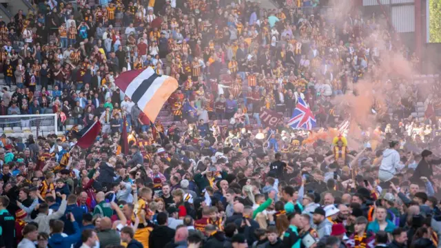 CRowds of people wave flags to celebrate
