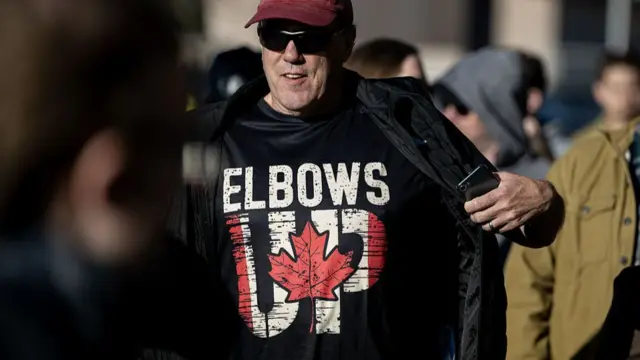 A supporter wearing an 'Elbows Up' tshirt to a Mark Carney rally in April 2025