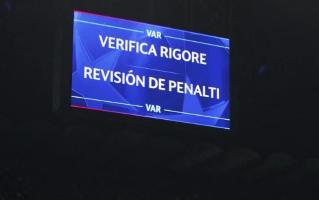 A big screen displays a VAR review message as a penalty to FC Barcelona is changed to a free kick