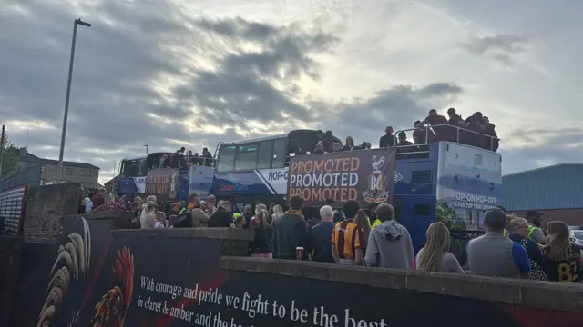 Fans looking at the Bradford City bus with 'promoted' written on it