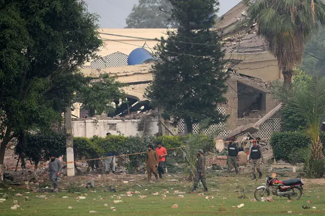 Paramilitary soldiers inspect a collapsed building of a complex in Muridke after India's strikes