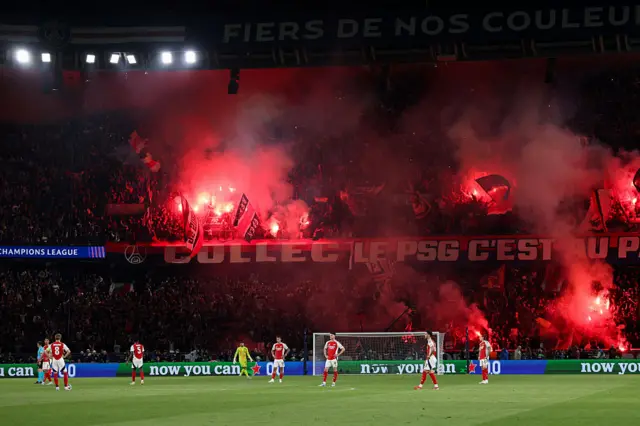 Arsenal players in front of PSG ultras
