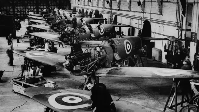 Black and white image of a line of Spitfires in the factory