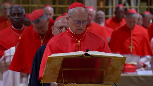 A cardinal takes the oath in the Sistine Chapel - he is wearing red and white