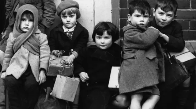 Black and white image of five young children waiting for evacuation from Southampton in 1940