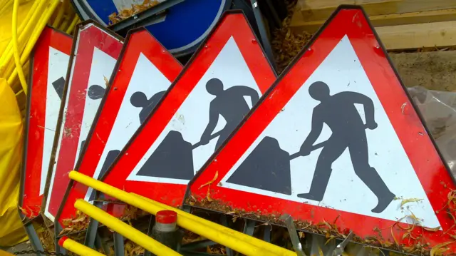 Five road works signs on top of eachother.