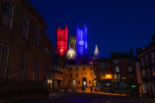 The towers of Lincoln Cathedral illuminated red, white and blue.