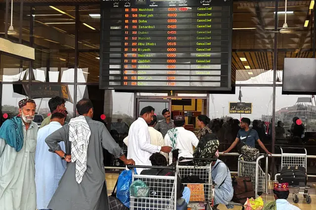Passengers wait at Jinnah International Airport after all domestic and international flights were cancelled in Karachi on May 7, 2025