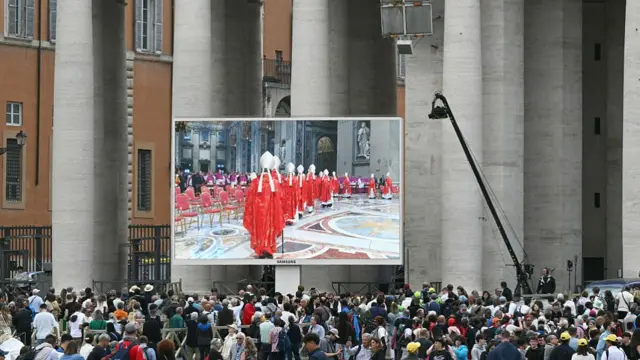 A picture of people watching Mass in the square