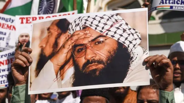 People holding a placard with Masood Azhar's picture during a protest in India in 2019