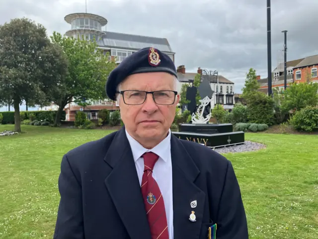 Veteran Paul Ogle dressed in a blue blazer and wearing his medals, a regiment tie and beret.