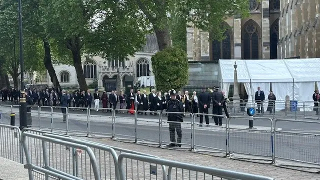 Keir Starmer followed by MPs as they walk along the side of Westminster Abbey before the service