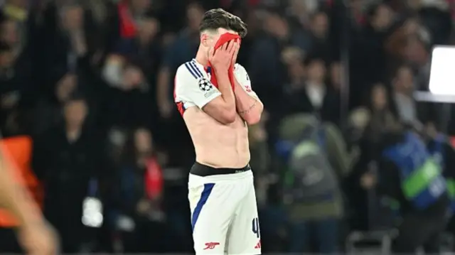Declan Rice covers his face during Arsenal's defeat to PSG