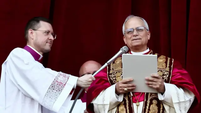 The pope speaks into a microphone