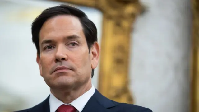 Marco Rubio wearing a red tie and black suit