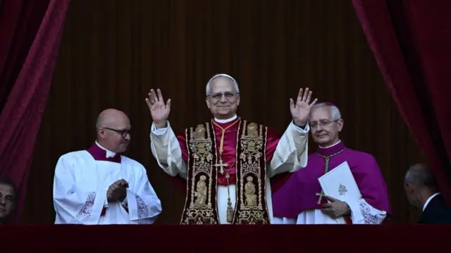 The new pope, standing on the balcony with his hands raised