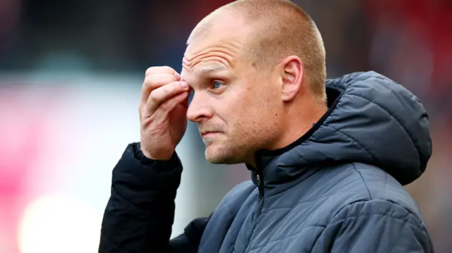Liam Manning scratches his head