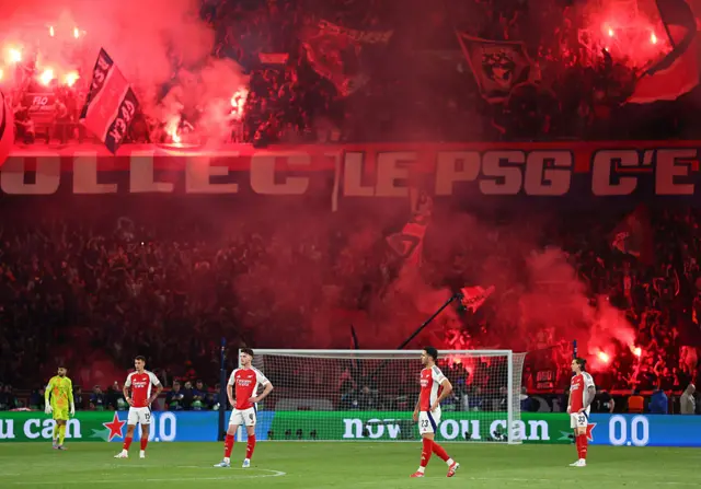 Arsenal players look dejected in front of PSG fans