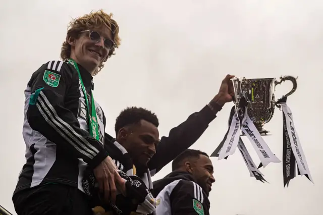 Newcastle United player, Jacob Murphy holds the League Cup aloft in celebration