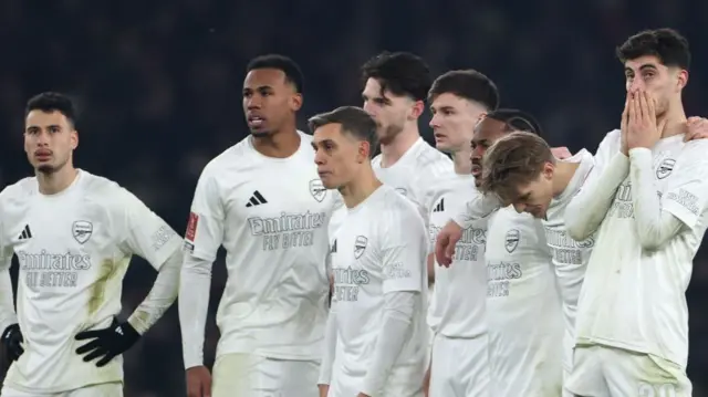 Arsenal players looking disappointed as they lose an FA Cup penalty shootout against Manchester United in 2025