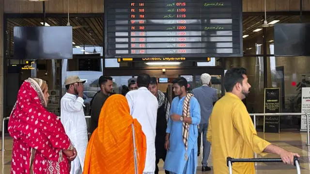 Passengers wait at Jinnah International airport after all domestic and international flights were cancelled in Karachi on May 7, 2025