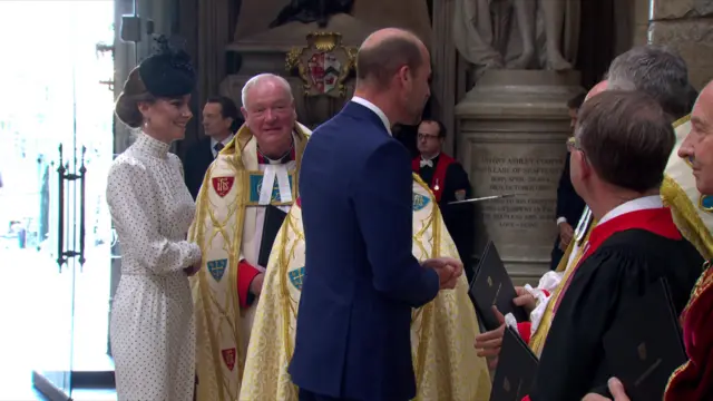 Princess of Wales (L) speaks to members of the clergy as Prince of Wales stands ahead of him chatting to priests