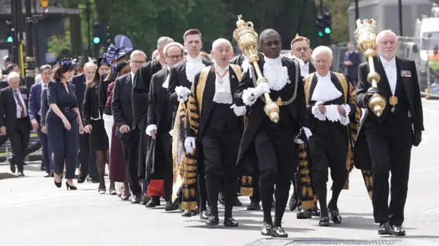 MPs and peers walk in procession from the Palace of Westminster in London to Westminster Abbey