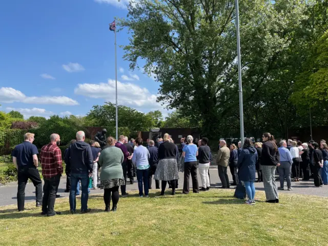 Hampshire and Isle of Wight Fire and Rescue Service joining events at the service headquarters - standing on a patch of grass by a memorial