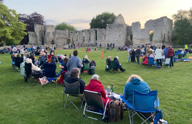People sit in chairs at Bishops Waltham ruins waiting for beacon lightning for VE Day 80