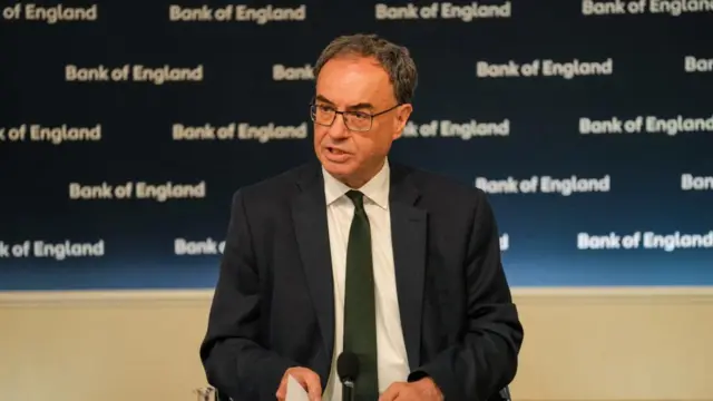 Bank of England Governor Andrew Bailey speaks during the Monetary Policy Report press conference in London. He wears a suit and glasses.