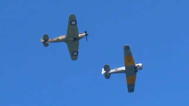 A picture of planes flying in the sky. There is two grey planes.