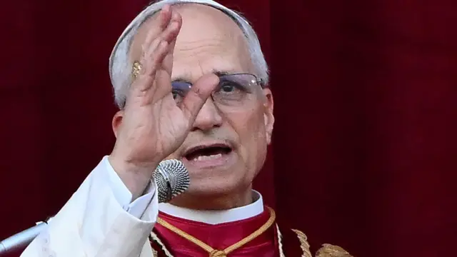 Pope Leo XIV speaking to on lookers dressed in red and white regalia