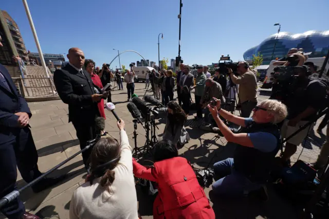 Dozens of reporters are shown listening to interviews outside court after the guilty verdicts in the Sycamore Gap trial were delivered. Some reporters are kneeling on the ground and some are standing behind cameras