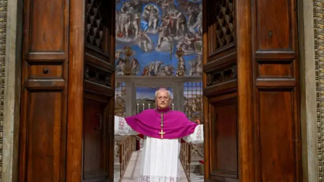Archbishop Diego Giovanni Ravelli dressed in religious garments closing the doors of the Sistine Chapel