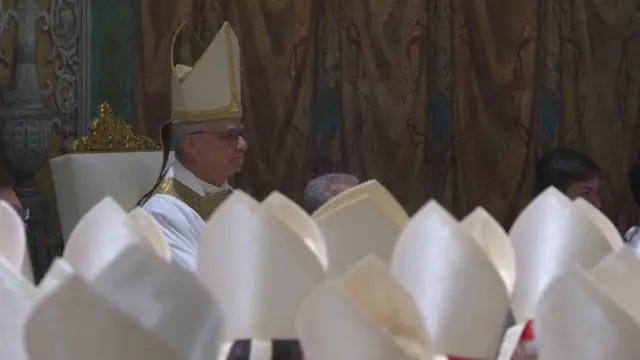 Pope Leo in his white mitre with gold trim, carindals wearing simpler white mitres in the foreground