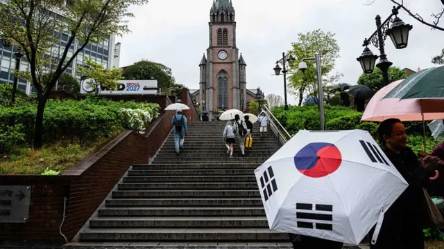 People walk up the stairs towards Myeongdong Cathedral in Seoul on 22 April 2025