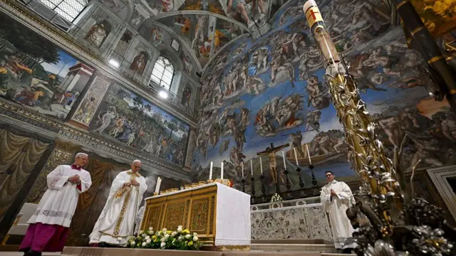 worms-eye view of the Sistine Chapel ceiling, elaborately painted by Michelangelo with figures of angels.