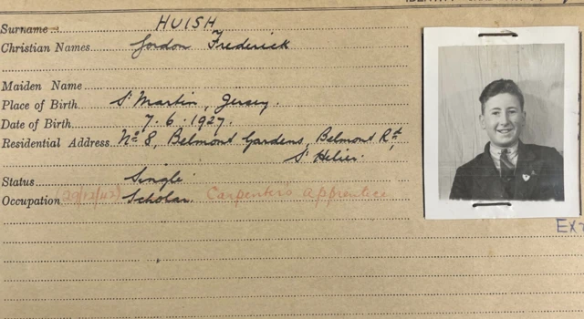 An ID card with a black and white photo of a young man with his name and address and other details on the left.